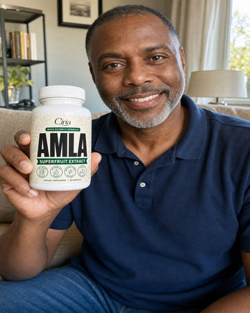 Man on a sofa holding a bottle of Ciria Amla