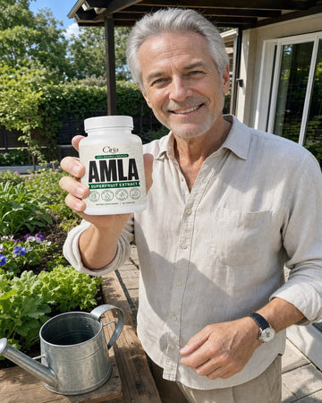 Man on a patio holding a bottle of Ciria Amla