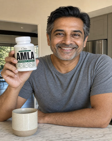 Man in a kitchen holding a bottle of Ciria Amla