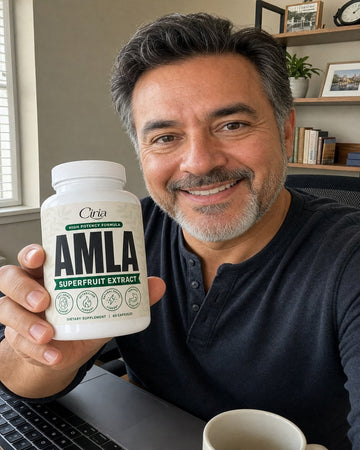 Man at a desk holding a bottle of Ciria Amla